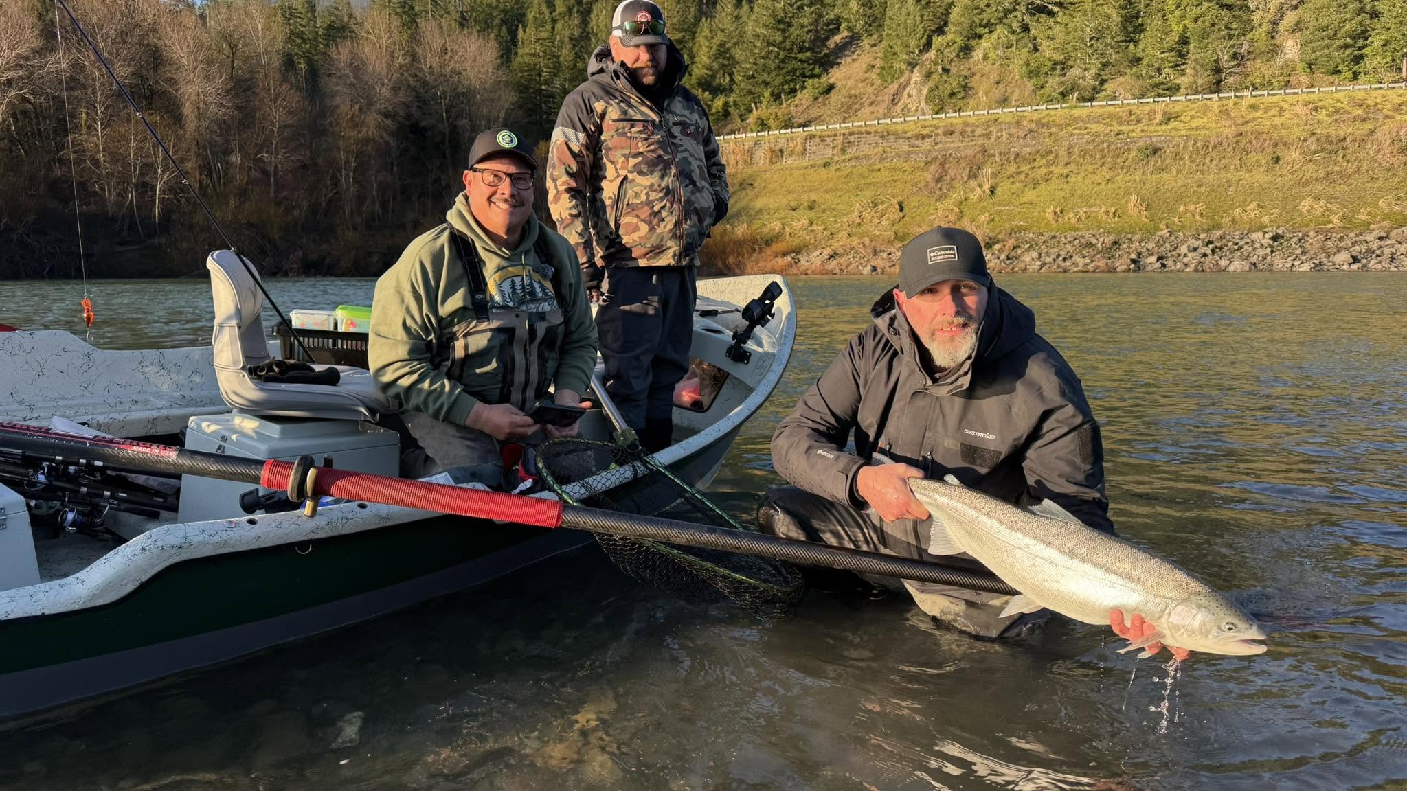 Two anglers with chrome steelhead from a drift boat